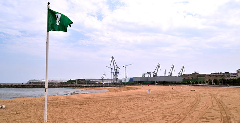 Playa del Arbeyal en La Calzada con los astilleros gijoneses al fondo