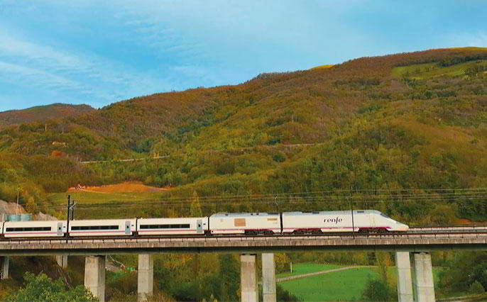 Imagem de um comboio de alta velocidade numa paisagem das Astúrias.