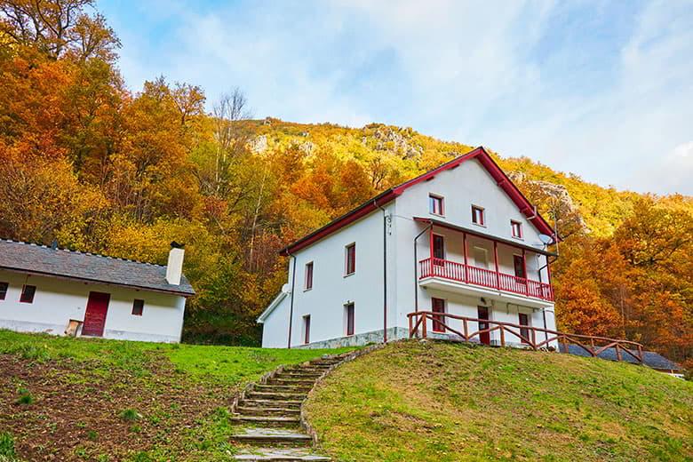 Vista del exterior del Centro de Recepción de Visitantes de Muniellos y su entorno rodeado del bosque en otoño.
