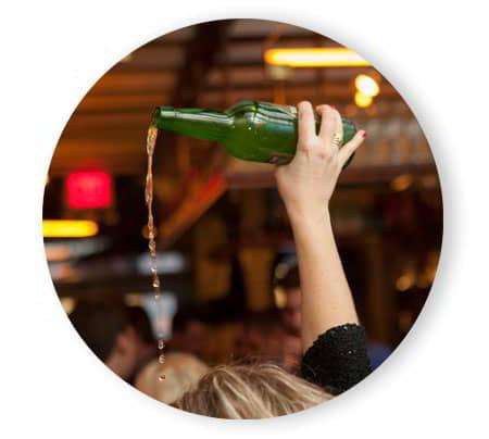 Escanciado de sidra donde se ve la botella que echa la sidra.