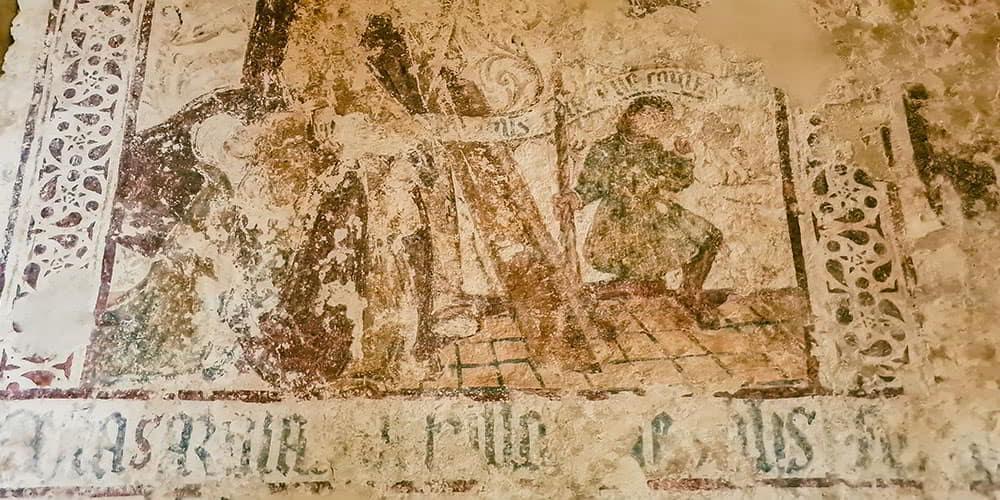 Fragmentos de pinturas murais no interior de San Miguel de Lillo, Astúrias, com figuras e textos antigos.