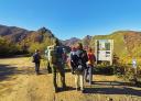 Group of hikers consulting the information panel at the start of the Valgrande Forest route.