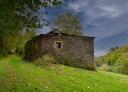 Casa de piedra con tejado de pizarra en un entorno rural de la Ruta de Mon.