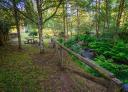 Picnic tables in the recreational area of Santa Eufemia, under trees and next to the river.