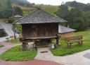 Traditional granary in front of the Ecomuseo del Pan in Villanueva de Oscos, next to the rest bench.