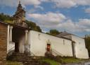 Church of Santa Eufemia in Villanueva de Oscos, with a white façade and a stone bell tower.