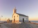 Capela branca no cabo de Luarca com vista para o mar Cantábrico.
