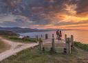 Pareja en mirador del Cabo Busto contemplando atardecer sobre el mar Cantábrico