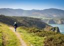 Senderista recorriendo senda costera del Cabo Busto con vistas al mar