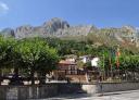 Square with trees and banners at the foot of the Monsacro in La Foz