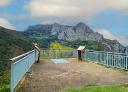 Viewpoint with information panels in front of limestone crags and green valleys