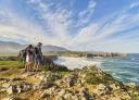 Grupo de senderistas en ruta costera con vistas al Cantábrico