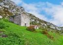 Stone hut on green slope of the Trespandiu road