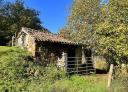 Traditional stone hut among trees and meadows