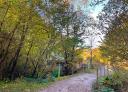 Rural road with bridge and typical hut in a wooded setting