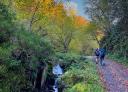 Hikers walking along an autumn path by the river Raigosu