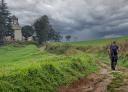 Randonneur arrivant à l'église de Pedroveya sous un ciel nuageux.