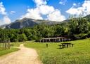 Prehistoric Park with picnic tables and mountains in the background in Teverga