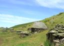 Stone huts on a mountainside with clear skies