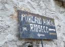 Worn sign indicating Rioseco Mining Village