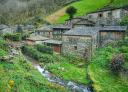Village of Os Teixois with stone houses and stream