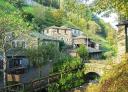 View of Os Teixois with a stone bridge and rural houses.