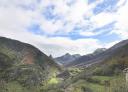Panoramic view of the mountainous landscape with a valley and some stone houses.