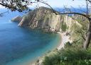 Aerial view of a sandy beach surrounded by impressive cliffs.