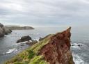 Vue sur des falaises impressionnantes et des falaises abruptes émergeant de la mer.