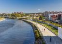 Panorámica de la ría de Avilés, con un paseo fluvial bordeando la orilla y edificios