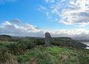 Monument mégalithique préhistorique dressé dans un paysage côtier herbeux