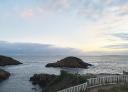 Rocky islet in the sea with small waves and blue sky with some clouds
