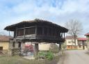 A traditional Asturian granary in a village surrounded by houses.