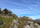 Rocky mountain landscape with a rustic stone house at the top