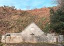 Stone water fountain surrounded by greenery