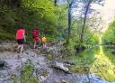 Gente caminando por un camino junto a la olla natural de agua cristalina en el bosque