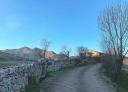 Stone country road with a rustic house and landscape in the background
