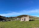 Traditional stone building in the middle of the countryside under the blue sky