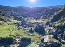 View from a trailhead over rocky terrain with spectacular mountains in the background.