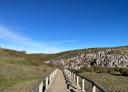 Hiker on wooden footbridge under the blue sky
