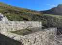 Fontaine en pierre avec paysage en arrière-plan sous un ciel bleu