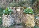Rustic stone fountain with vegetation