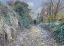 Hiker walks along a country road covered in dry leaves