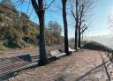 Resting area with benches and trees next to a river