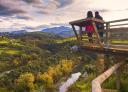 Elevated wooden viewing platform offers spectacular views of a wooded river valley.