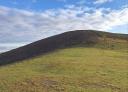 Green, clear hill under a sky of cloud
