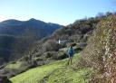 Hiker walking along a path with a mountainous landscape in the background.