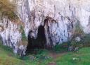 Large rocky cave with a wide entrance, part of a karst landscape.