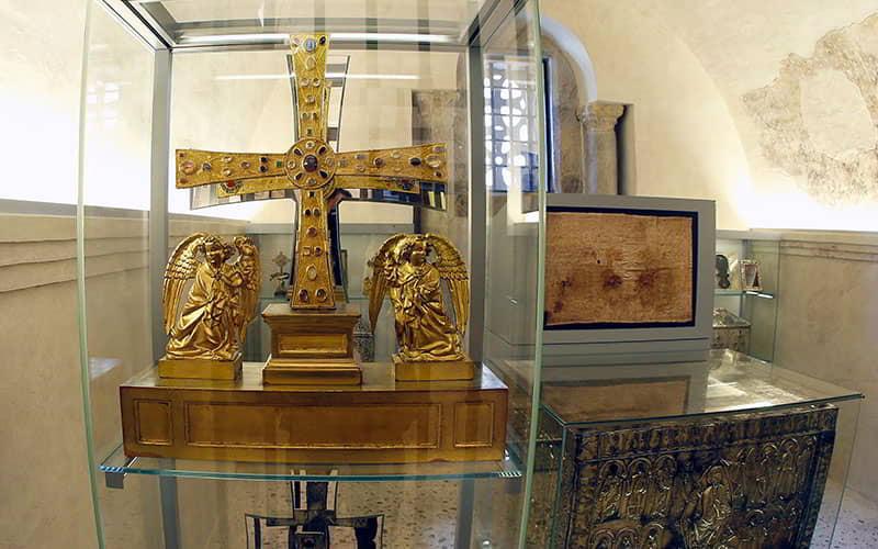 Reliquias de la Cámara Santa en la Catedral de Oviedo, incluyendo la Cruz de los Ángeles y el Arca Santa parcialmente visible.