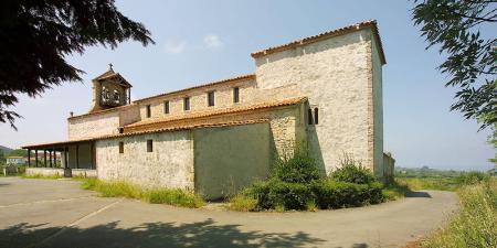 A igreja de Santiago de Gobiendes em Colunga com o seu campanário e pequenas janelas, e em primeiro plano a janela pré-românica...